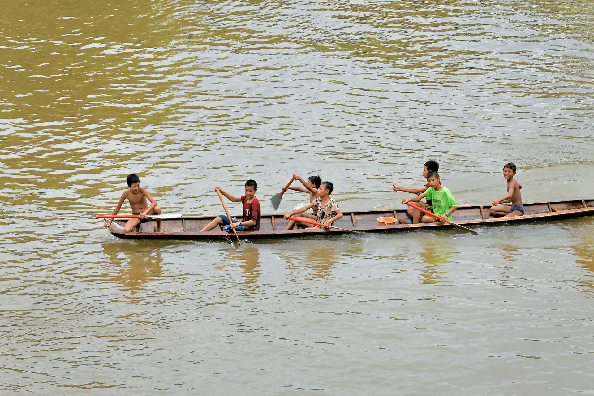 Kinder haben ihren Spaß beim Rudern auf dem Nam Khan-Fluss